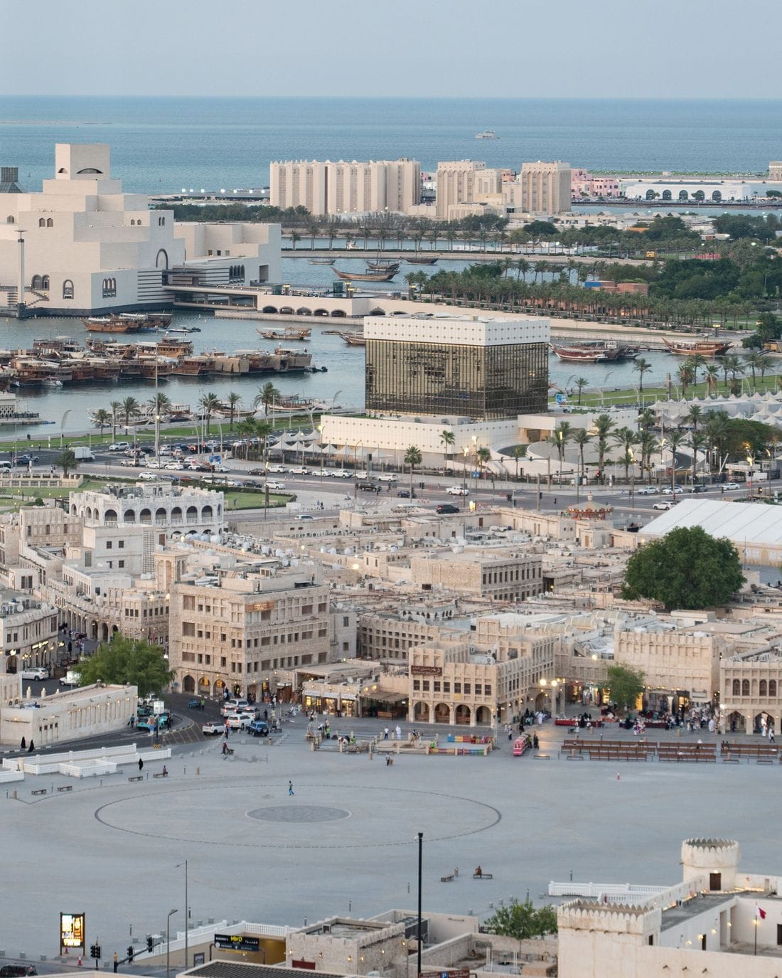 Traditional dhows on Doha Bay at dusk, with the West Bay towers beyond